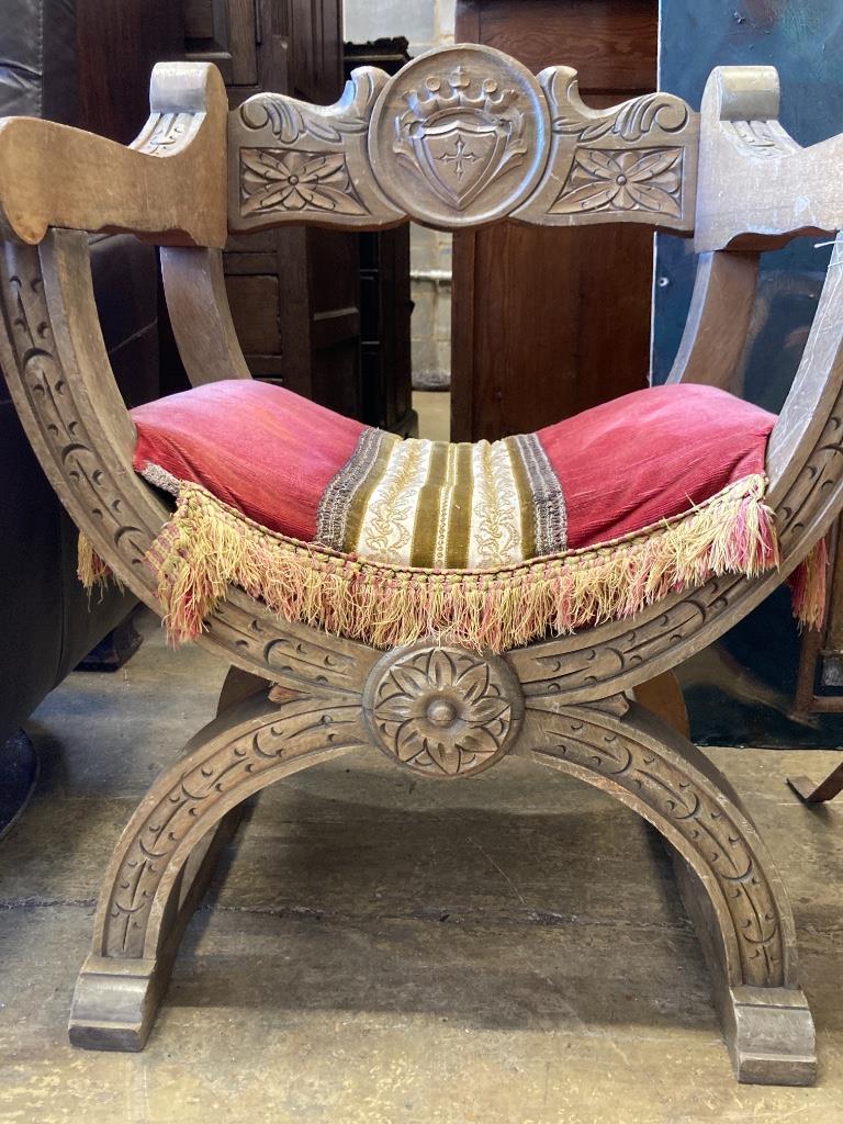 An 18th century style carved X frame oak chair, width 59cm, depth 49cm, height 77cm